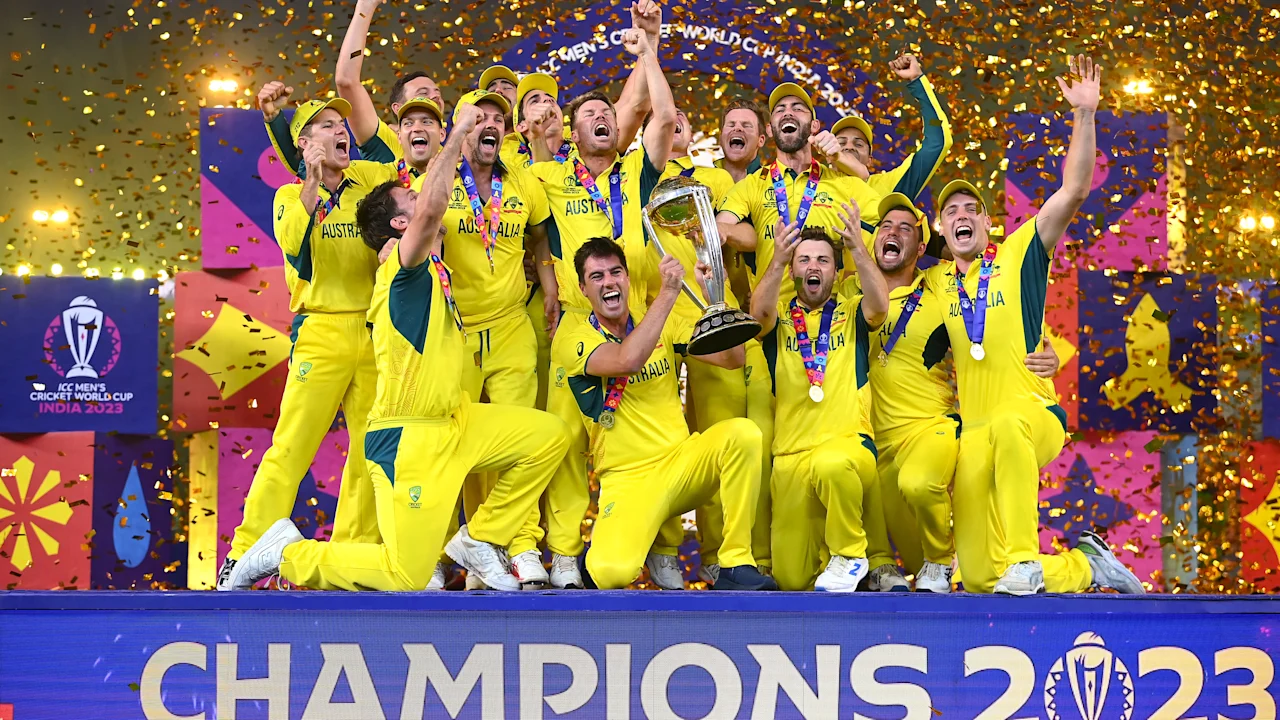 Australia’s players celebrate winning the 2023 Men’s Cricket World Cup with the trophy and gold confetti.