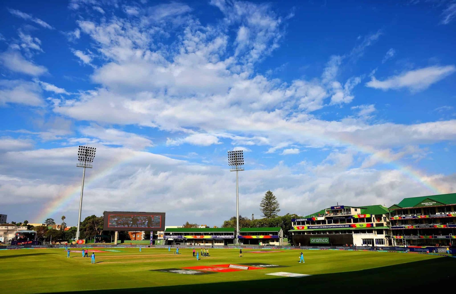 St George’s Park in Gqeberha, showing the playing field, green-roofed stands and floodlights beneath a rainbow.